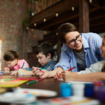 teacher helping preschool students