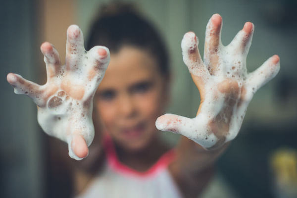 Little girl with soapy hands - wash hands often to avoid coronavirus