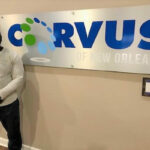 Corvus of New Orleans Franchisee Donald Valerie in front of Corvus sign