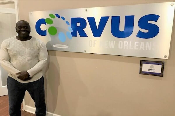 Corvus of New Orleans Franchisee Donald Valerie in front of Corvus sign