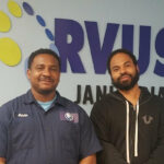 Two Corvus of St. Louis Franchise Owners (Darren Starks & Adrian West) pose for photo in front of Corvus sign