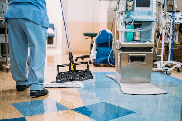 Janitor providing cleaning services in a doctor's office with a mop