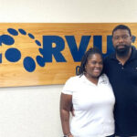 Corvus of San Antonio franchise owners Kelly and Patricia Simmons in front of Corvus sign