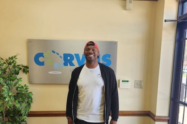 Corvus of Charlotte Franchise Owner Shon Hall in front of Corvus sign