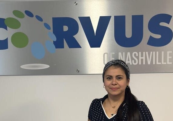 Corvus of Nashville Franchise Owner Laurybel Figueroa Villarreal in front of Corvus sign