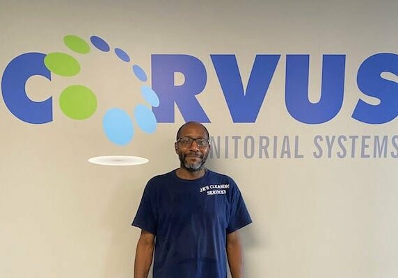 franchise owner Marcos Henderson in front of Corvus sign